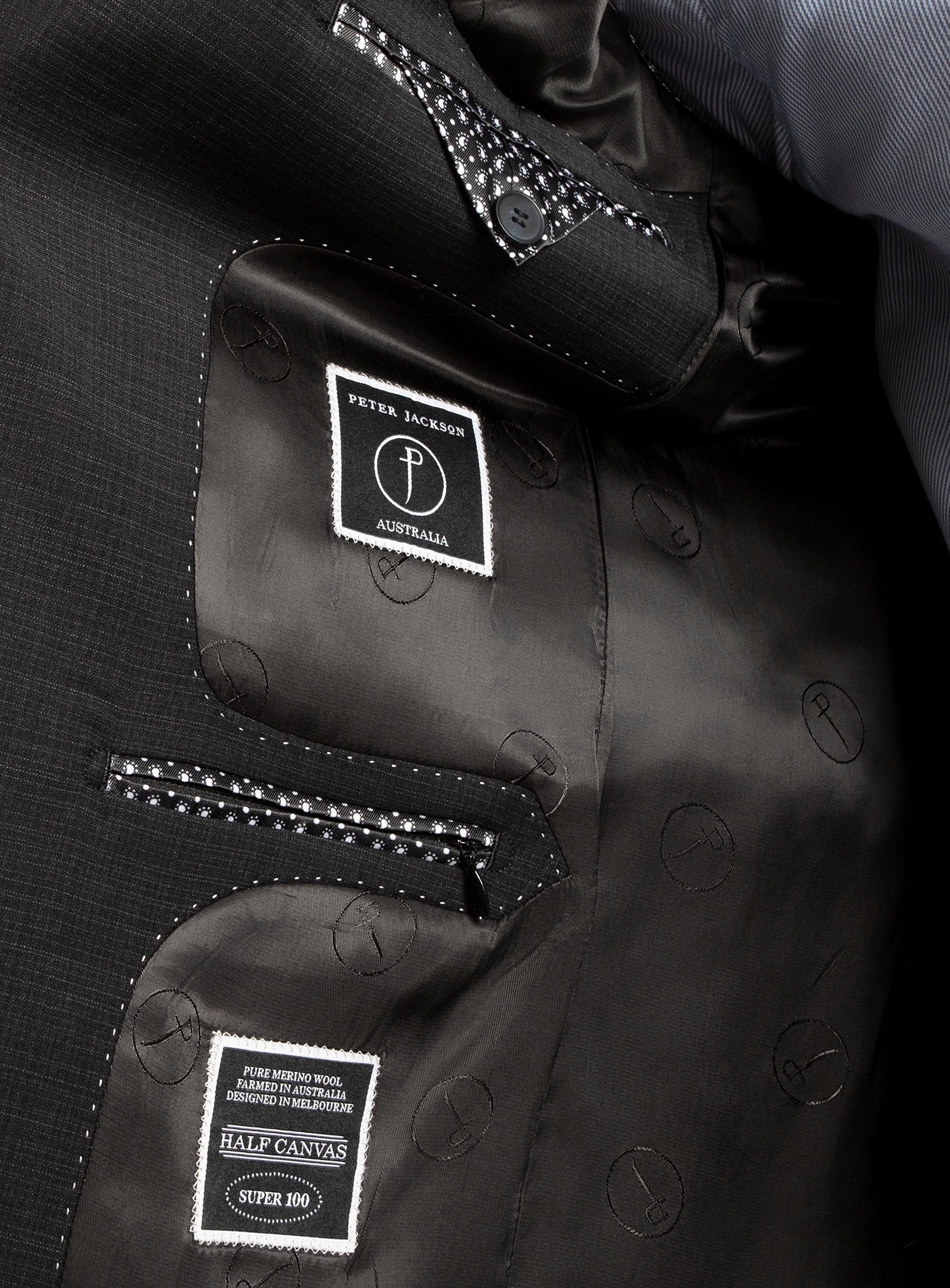 Close-up of a black jacket with brand labels on a dark background
