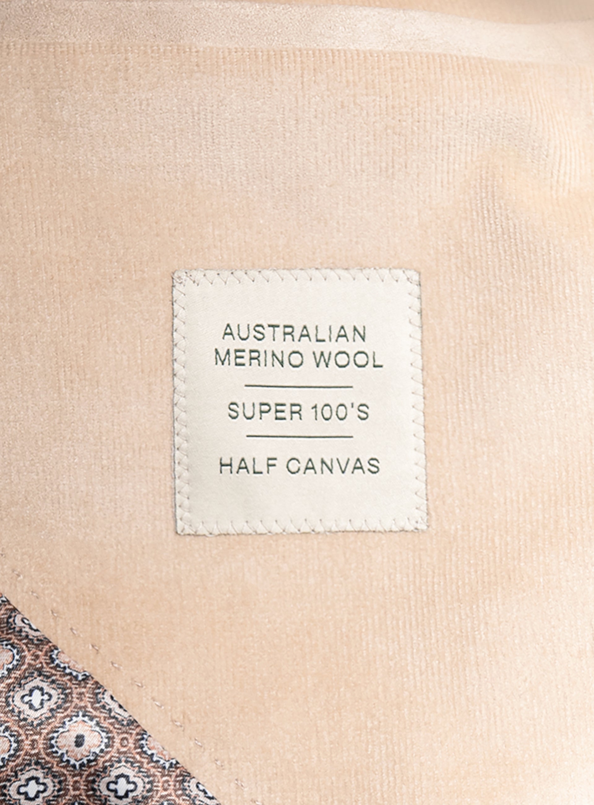 Label on a beige fabric product indicating 'Australian Merino Wool Super 100's Half Canvas'.