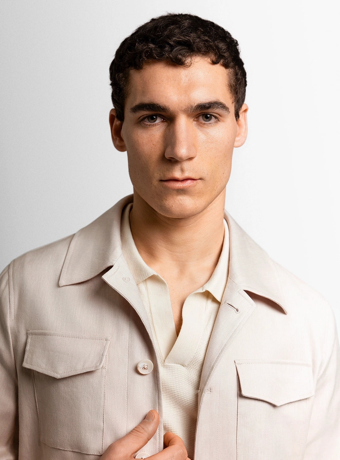 Man wearing a beige jacket against a plain background