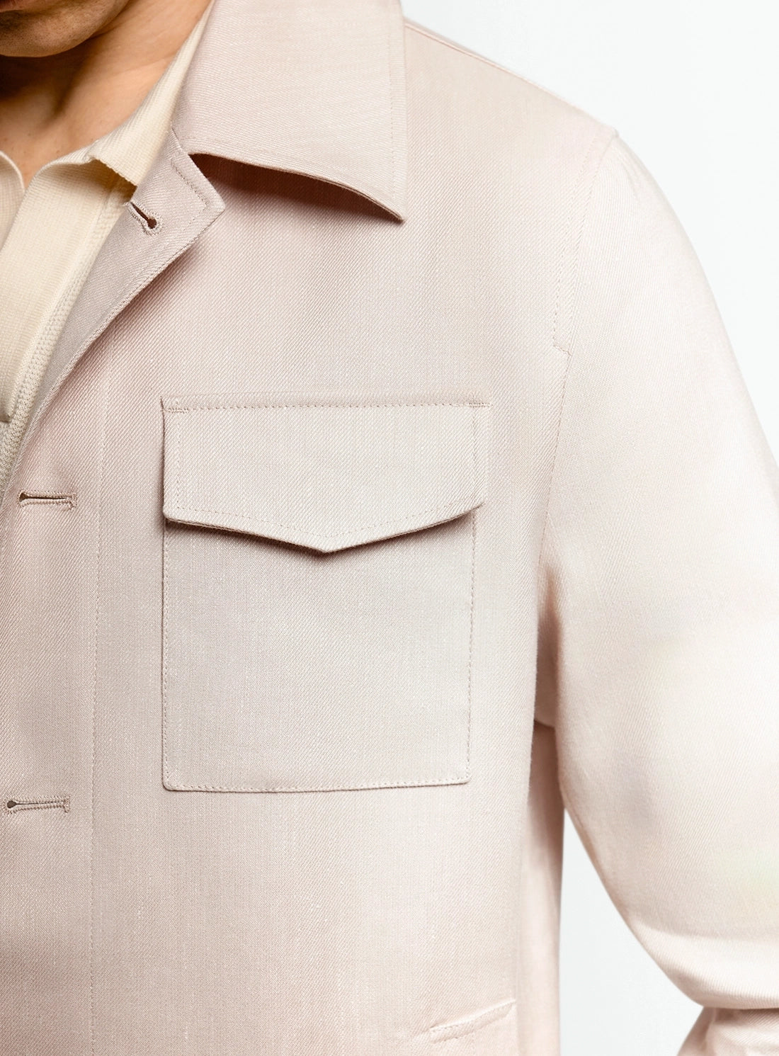 Close-up of a beige jacket with a pocket on a white background