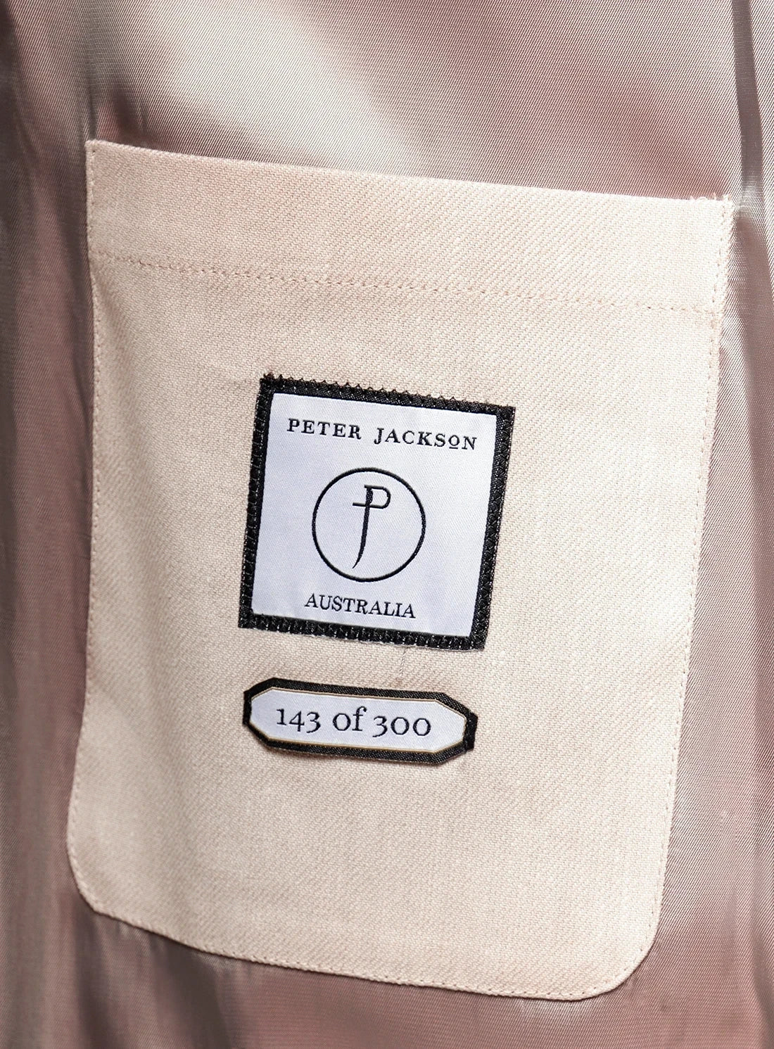 Close-up of a beige pocket with a brand label on a garment.