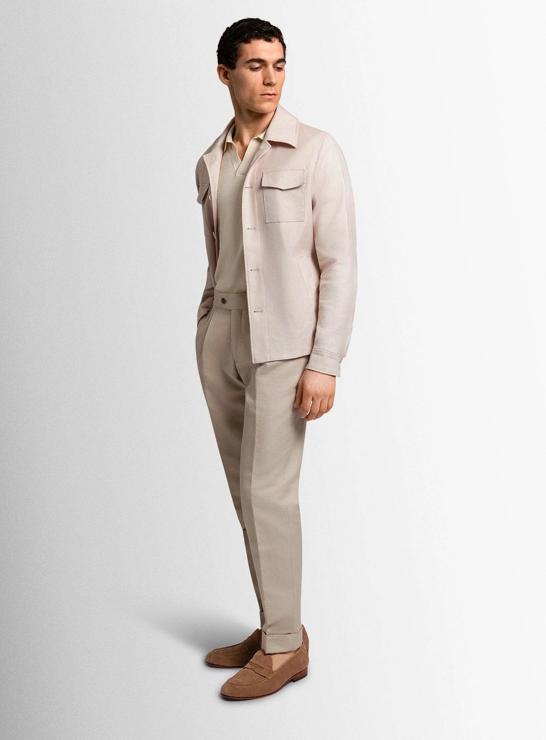 Man wearing a beige suit with a white shirt on a light gray background