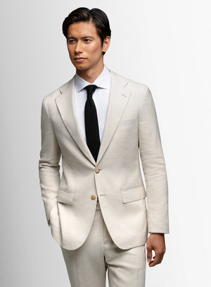 Man wearing a light gray suit with a black tie on a white background