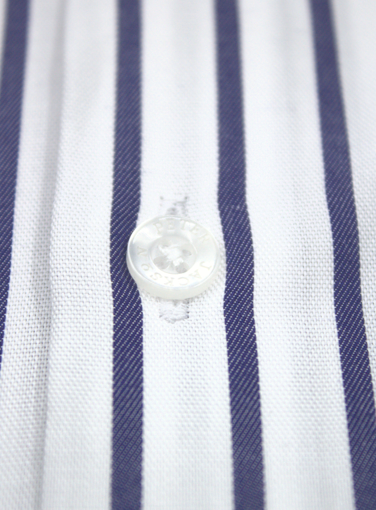Close-up of navy and white stripe fabric and transparent front button