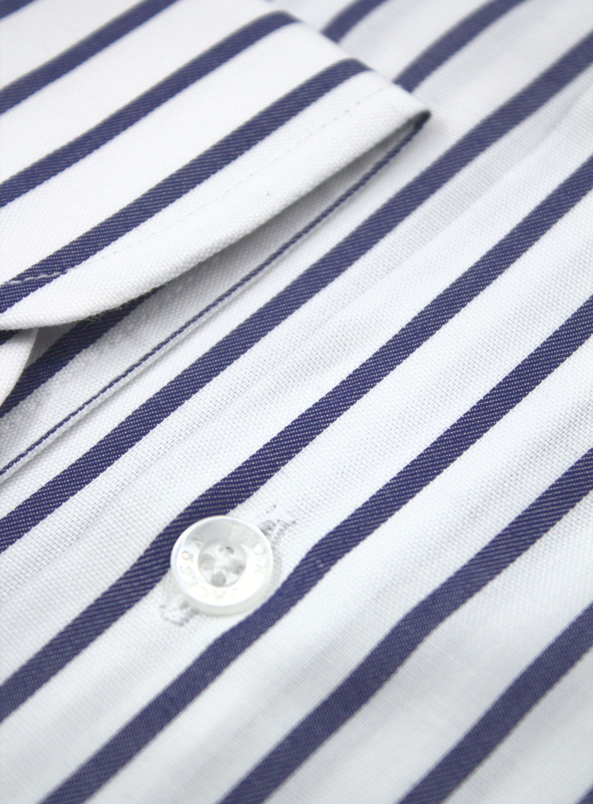 Sleeve placket and transparent button detail on the navy stripe shirt