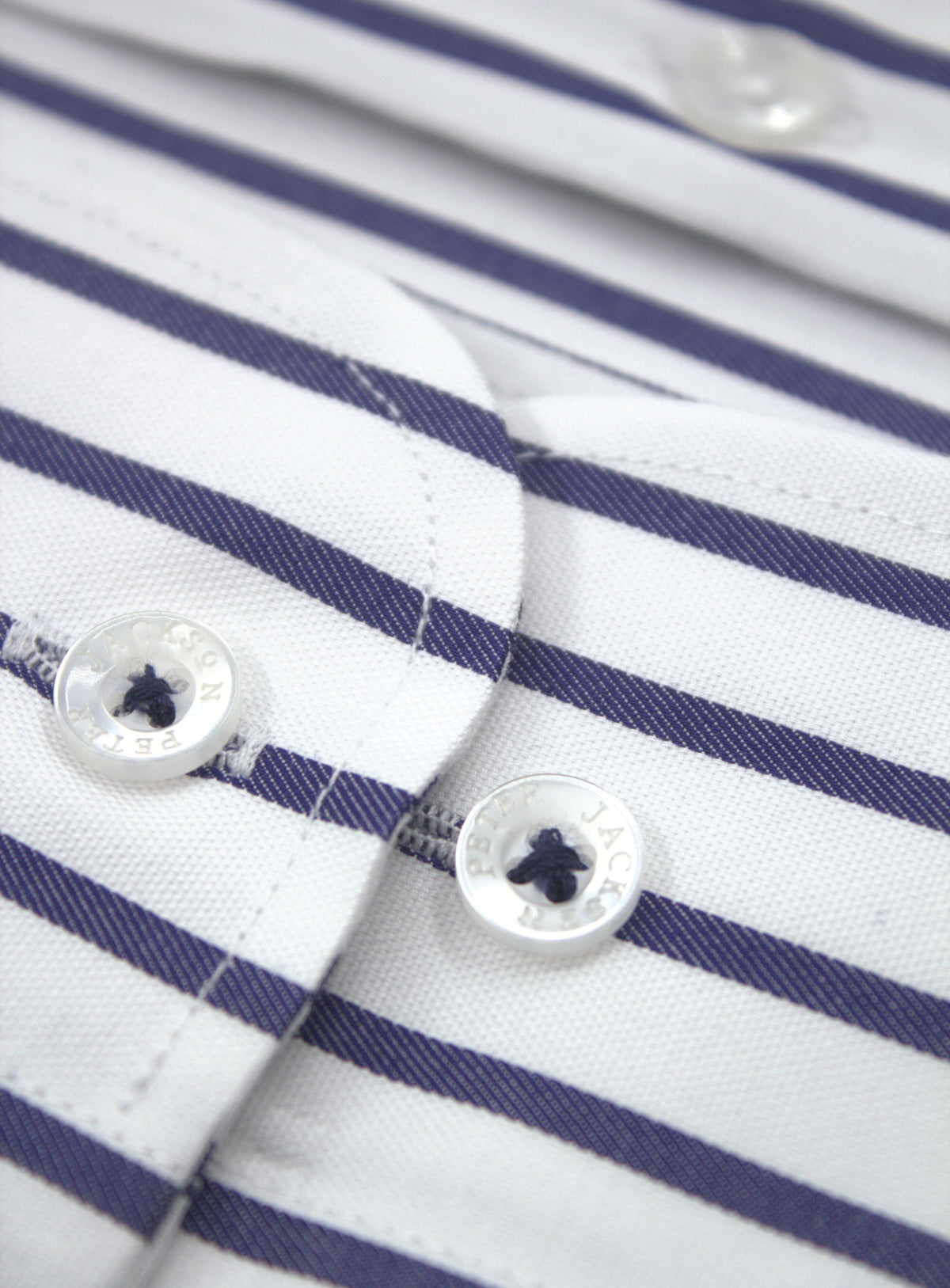 Rounded adjustable cuff with two button positions on the navy stripe shirt