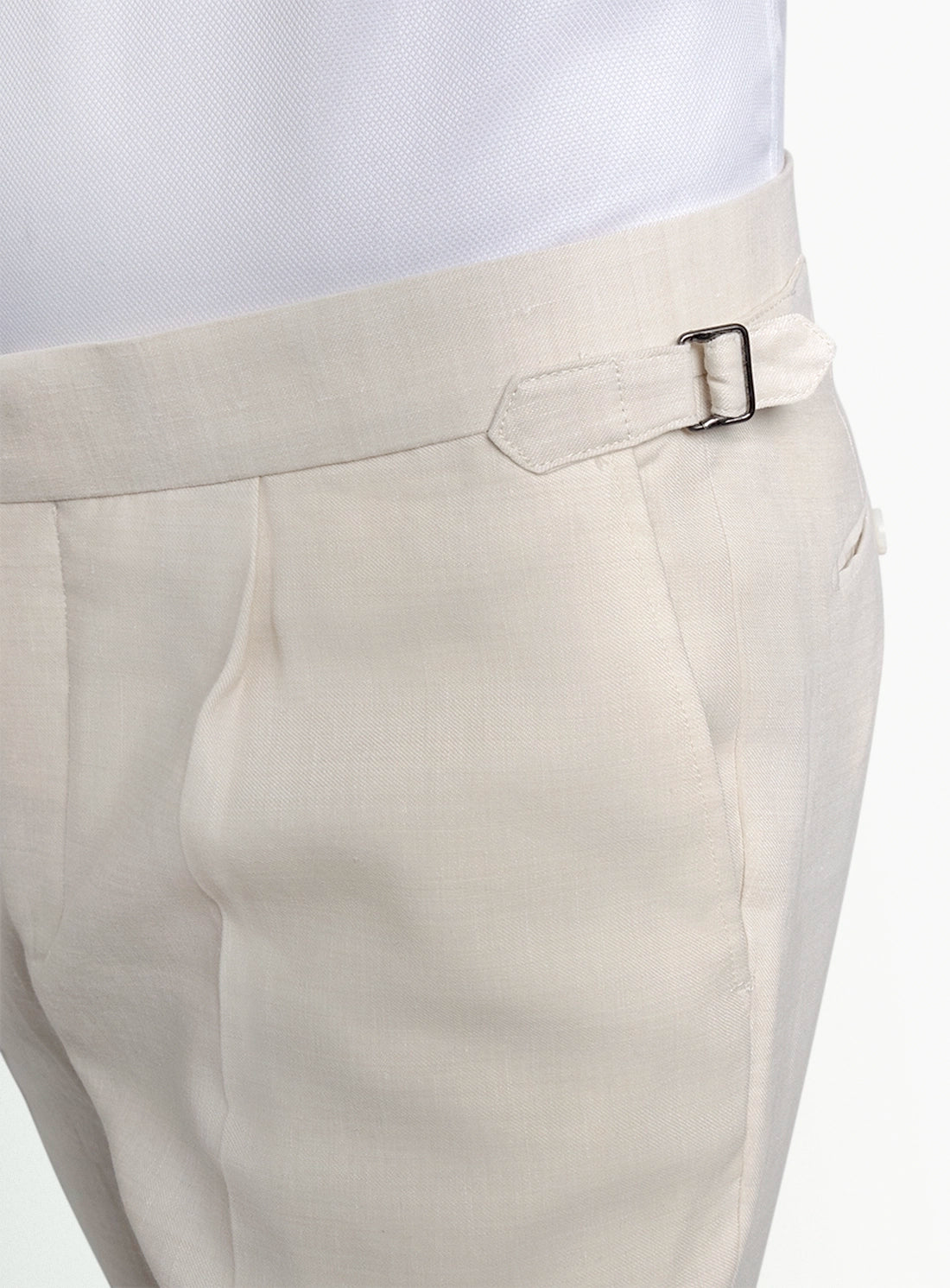 Close-up of beige pants with a belt on a white background