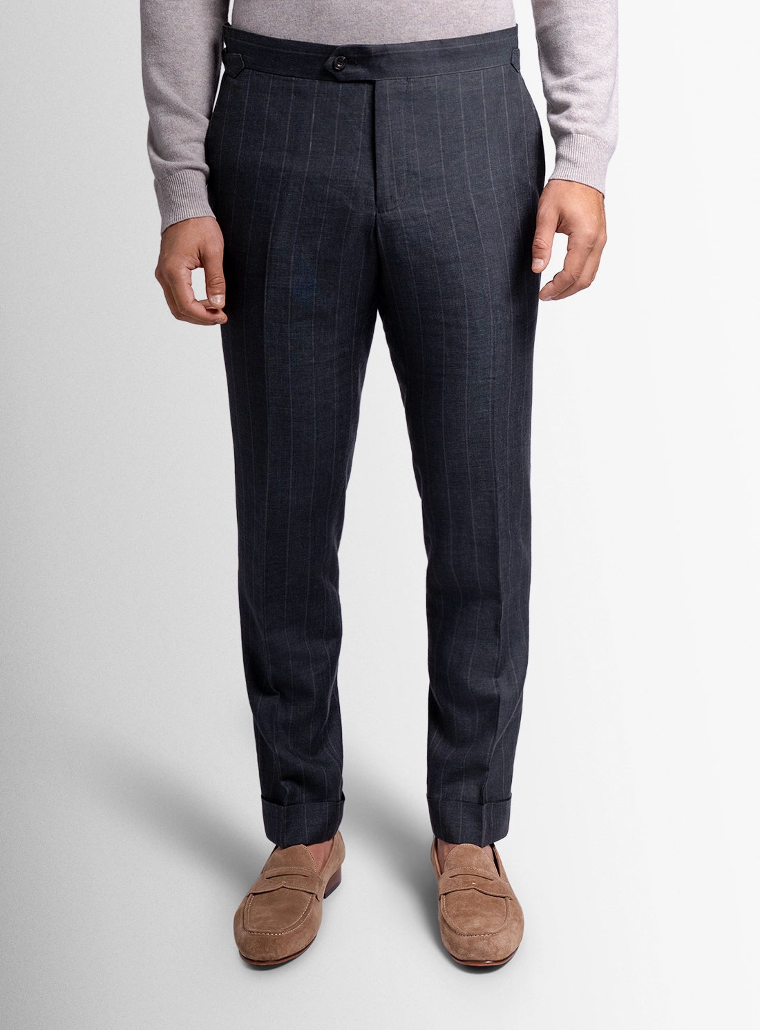 Dark gray pinstripe dress pants worn by a person on a light gray background