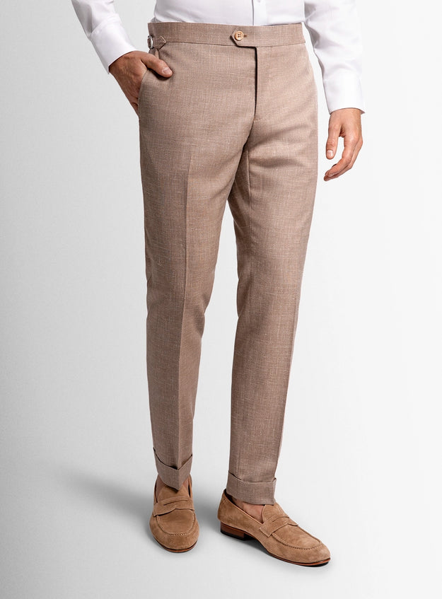 Beige checkered pants worn with a white shirt and brown shoes on a light gray background
