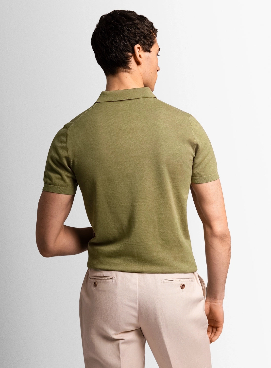 Green cotton polo shirt with a Peter Jackson label on a white background