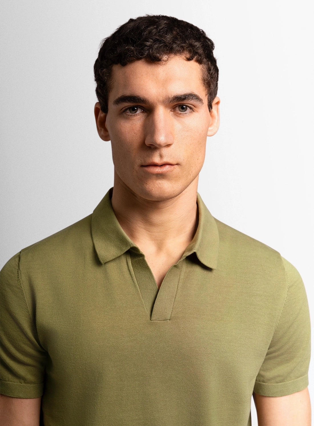 Green cotton polo shirt with a Peter Jackson label on a white background