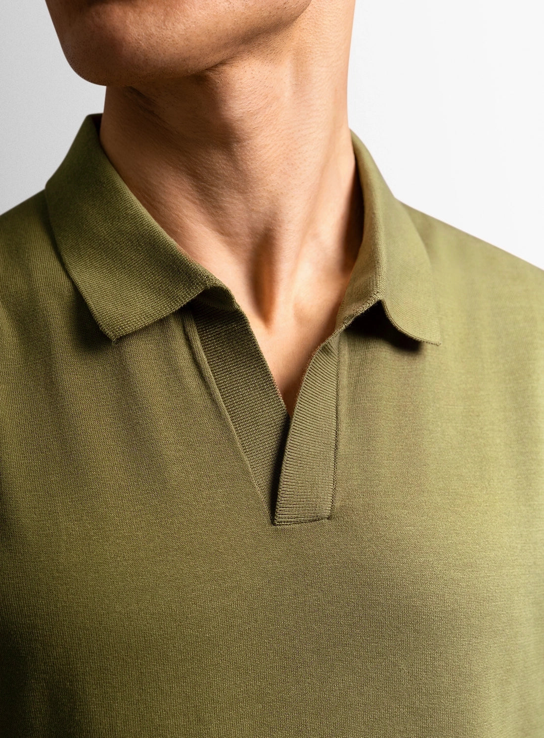 Green cotton polo shirt with a Peter Jackson label on a white background