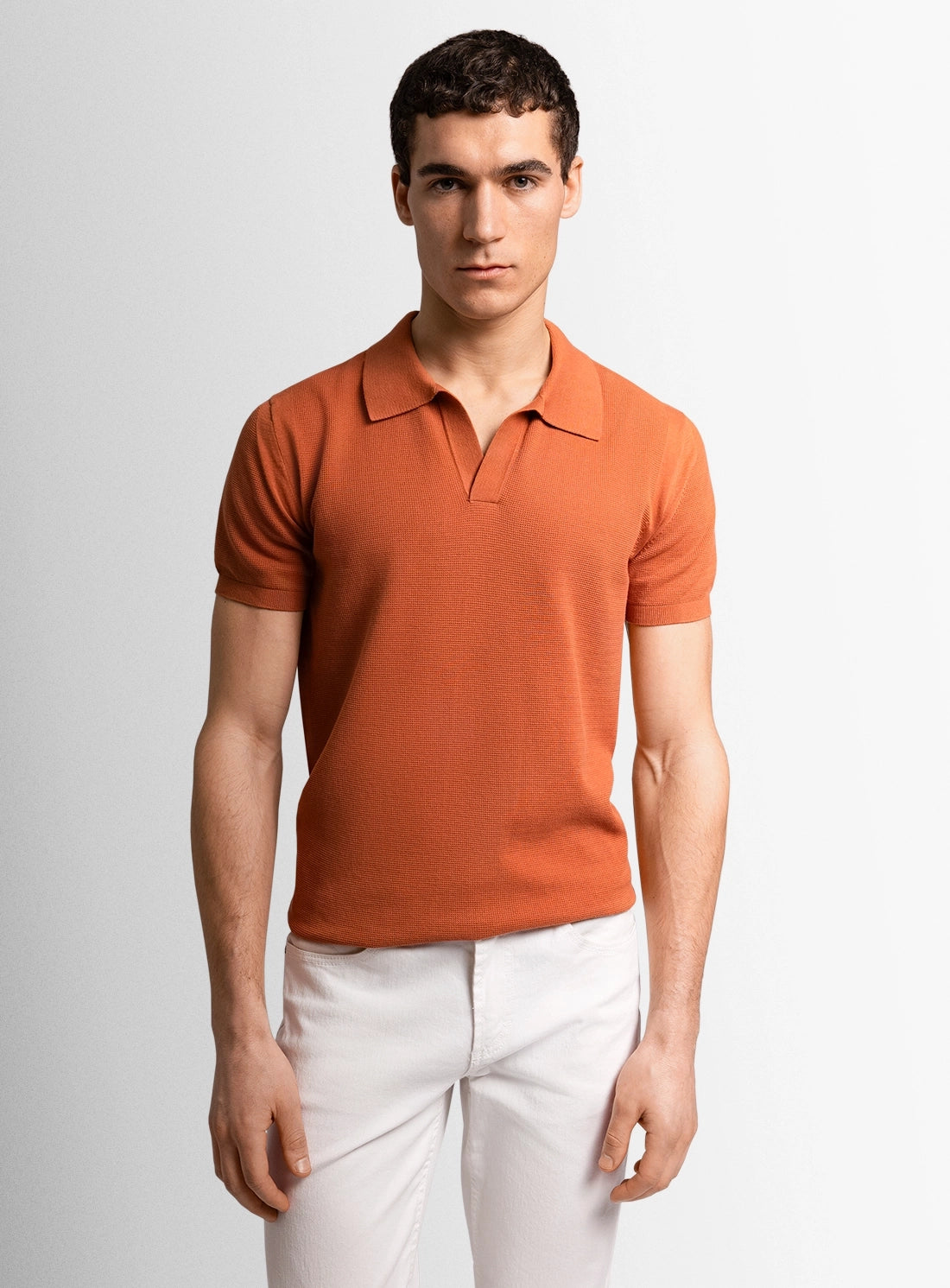 Orange cotton polo shirt with a Peter Jackson label on a white background