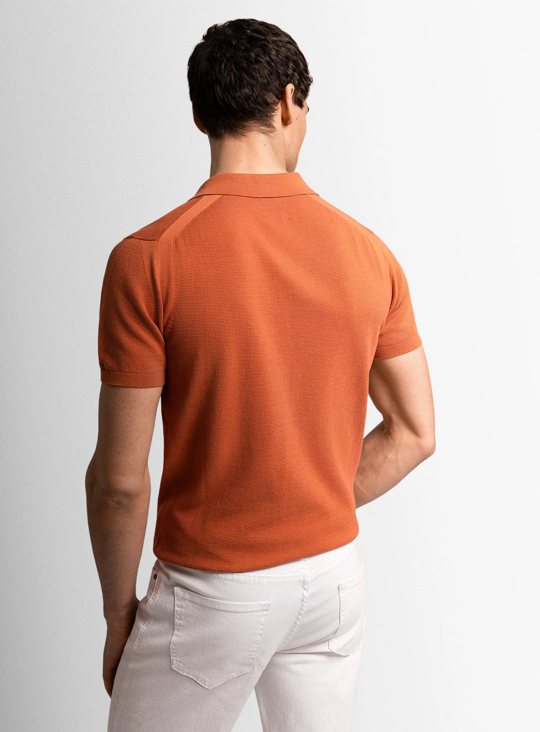 Orange cotton polo shirt with a Peter Jackson label on a white background