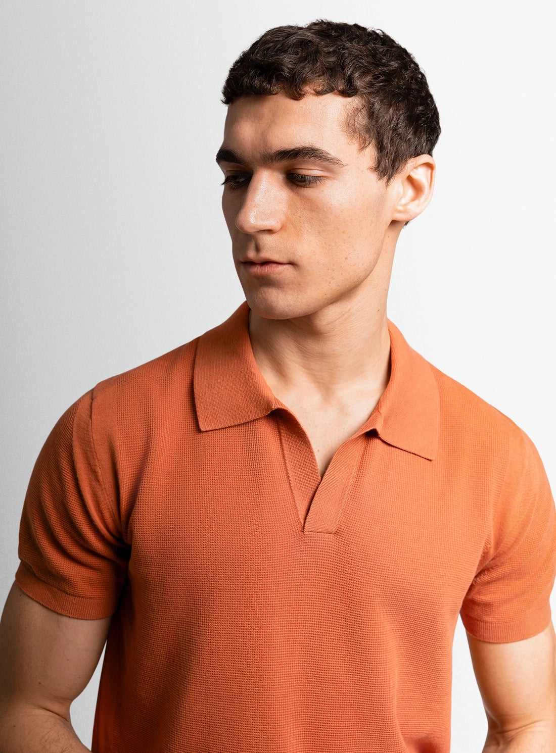 Orange cotton polo shirt with a Peter Jackson label on a white background