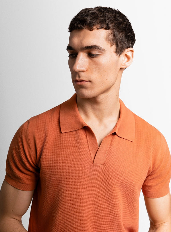 Orange cotton polo shirt with a Peter Jackson label on a white background