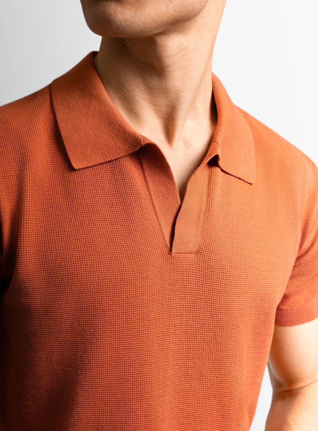Orange cotton polo shirt with a Peter Jackson label on a white background