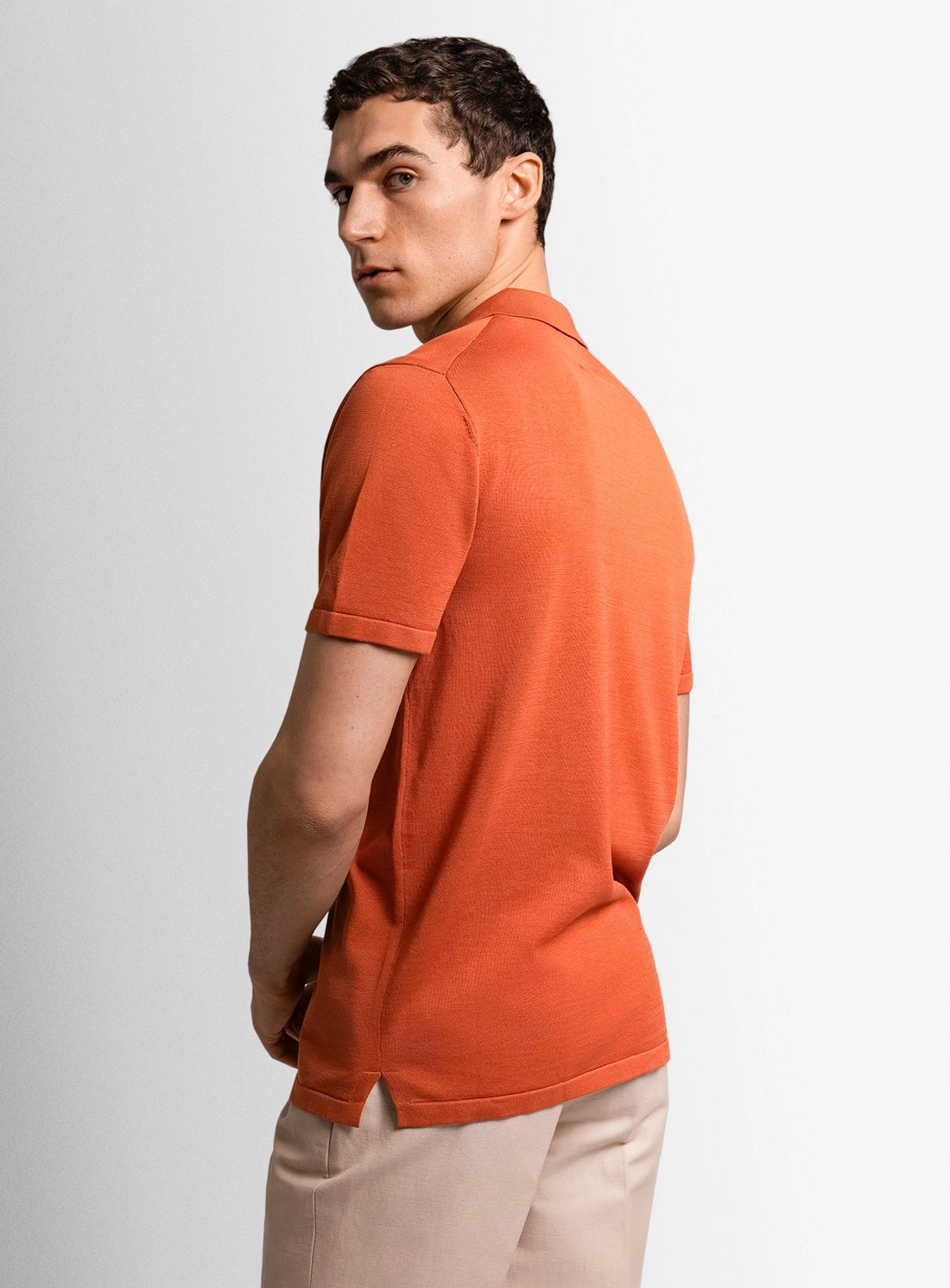 Orange cotton polo shirt with a Peter Jackson label on a white background