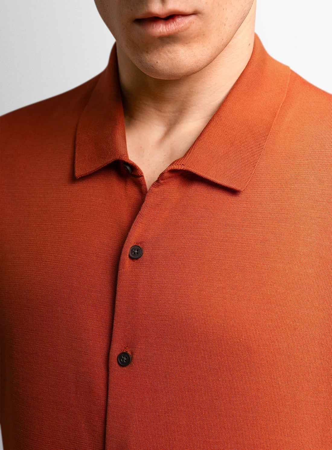 Orange cotton polo shirt with a Peter Jackson label on a white background
