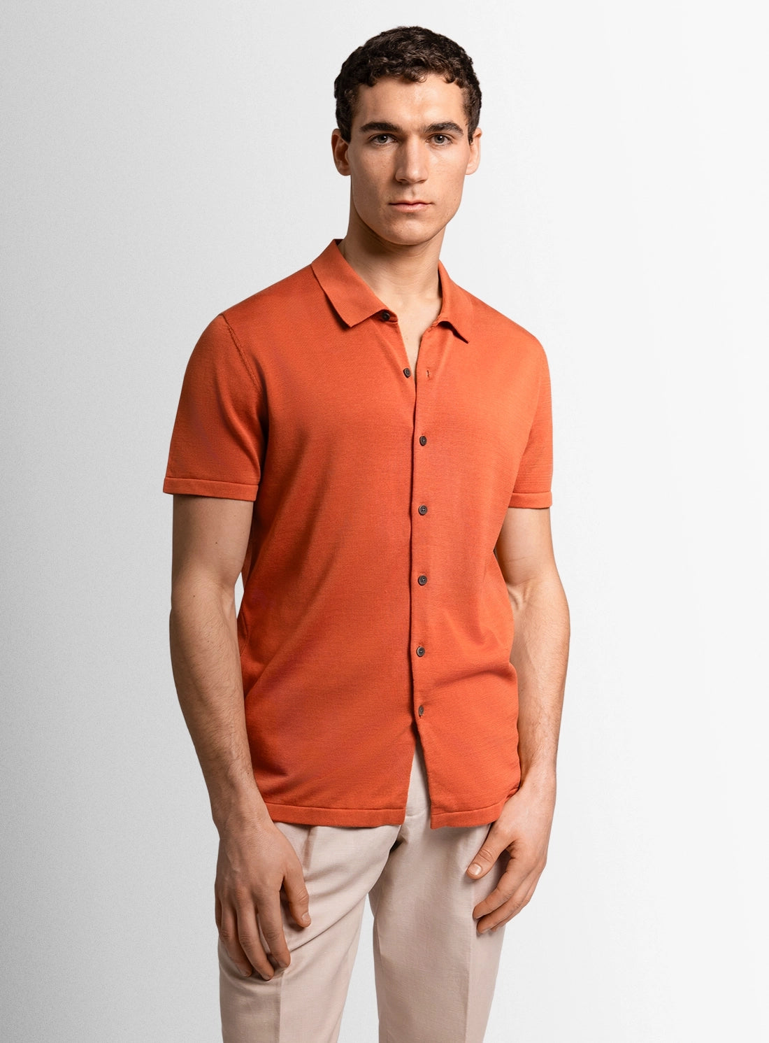 Orange cotton polo shirt with a Peter Jackson label on a white background