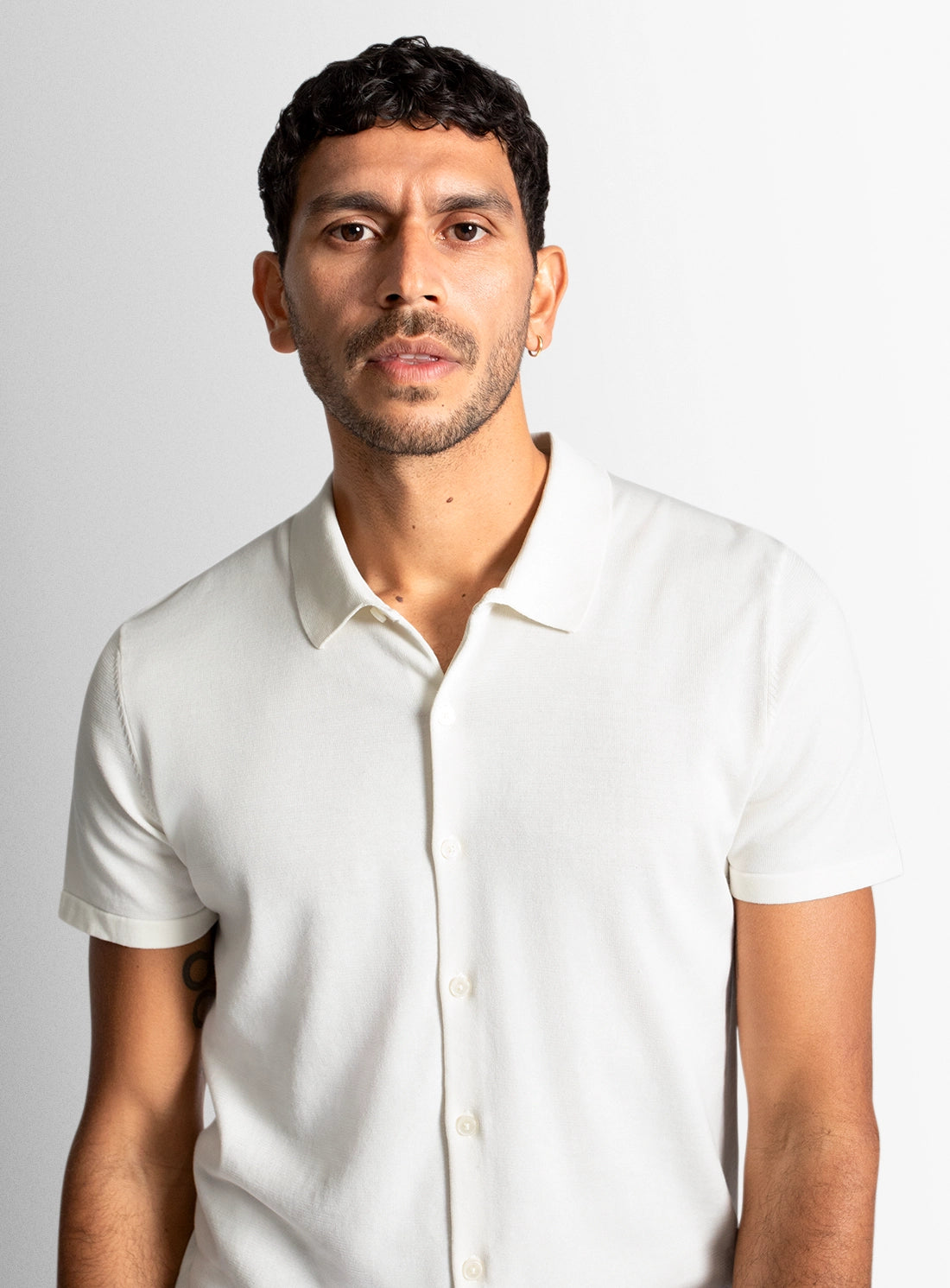 Man wearing a white shirt against a plain background