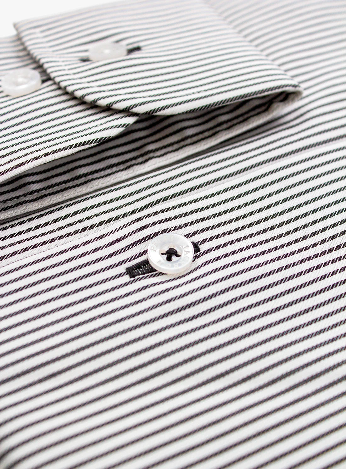 Close-up of a black and white striped shirt with a button detail.