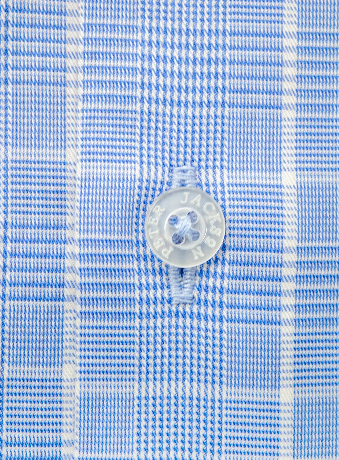 Close-up of a blue and white checkered fabric with a button.