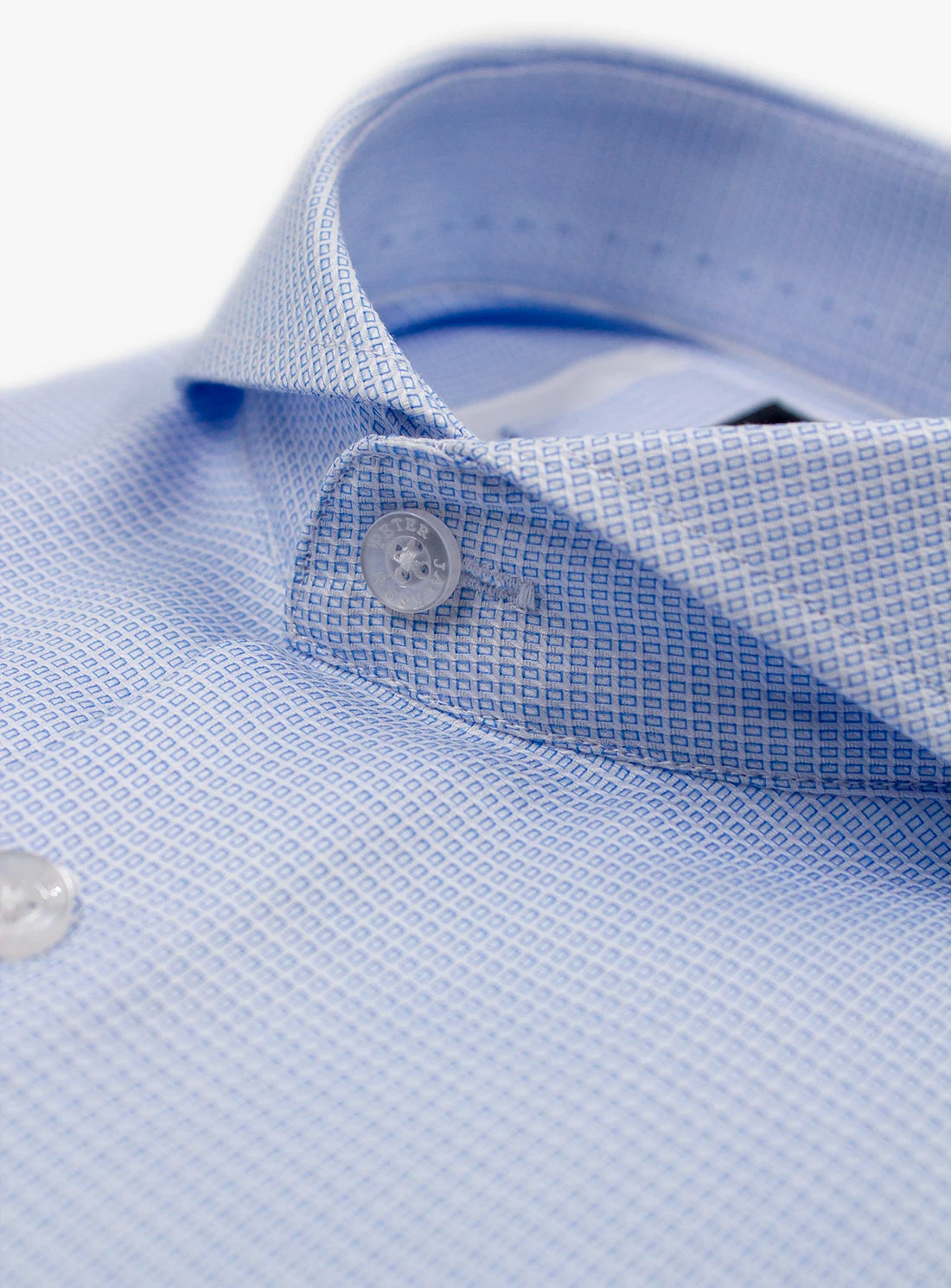 Close-up of a light blue textured shirt with buttons on a white background