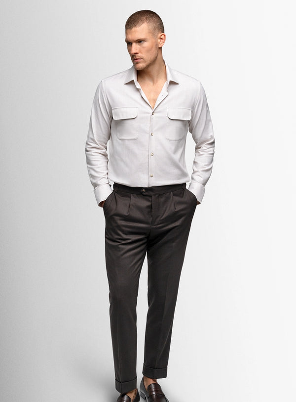 Man wearing a light gray shirt and dark gray pants on a white background