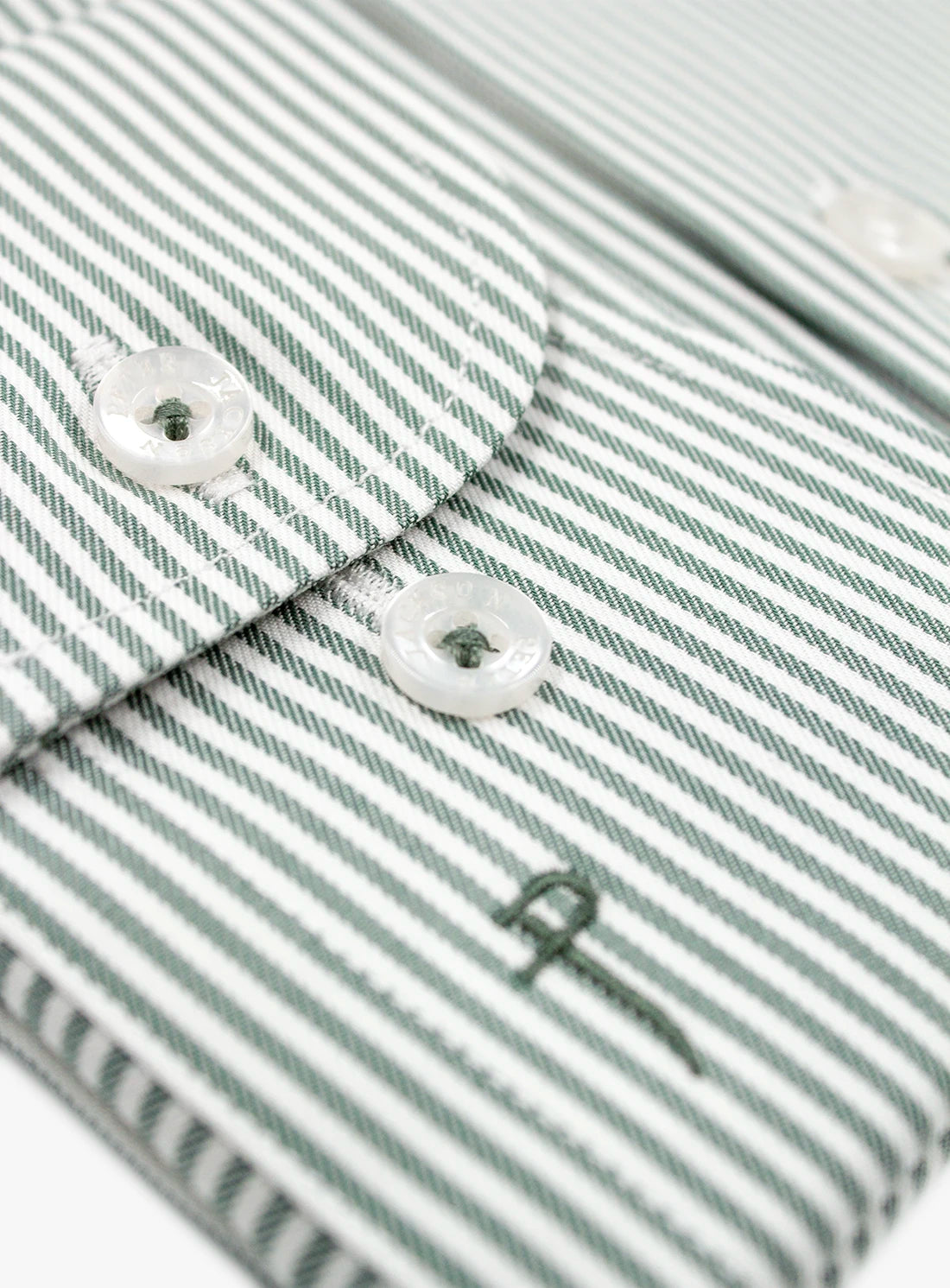 Close-up of a striped fabric with buttons and a brand logo.