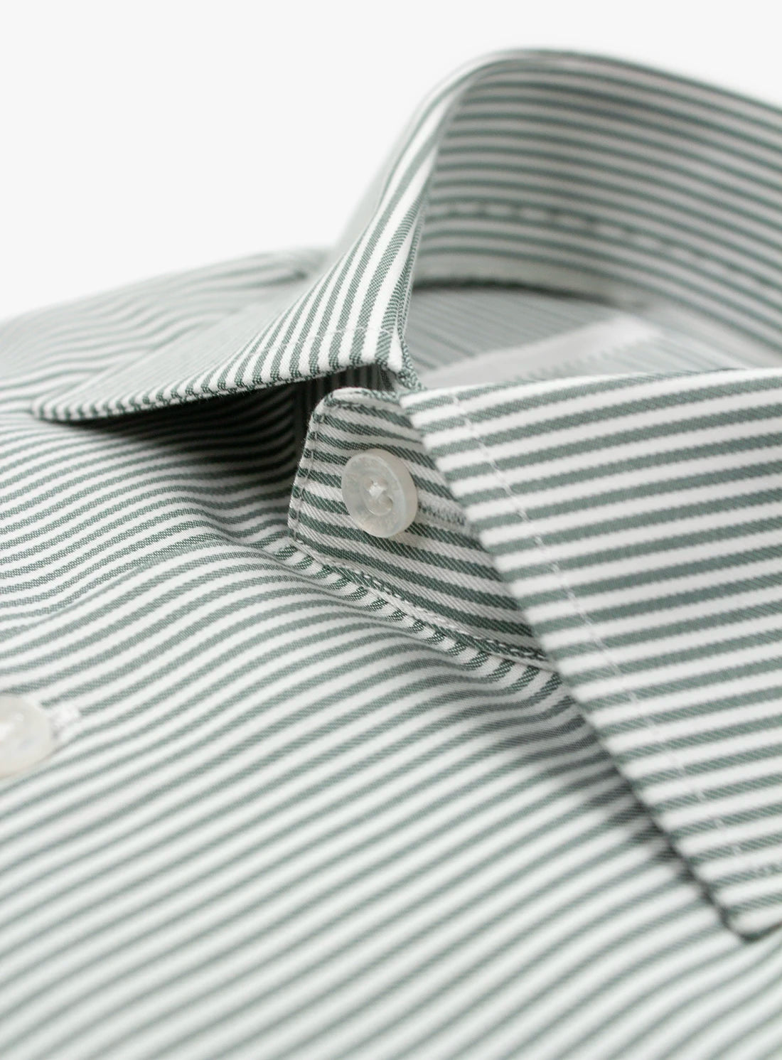 Close-up of a gray and white striped shirt with a button.
