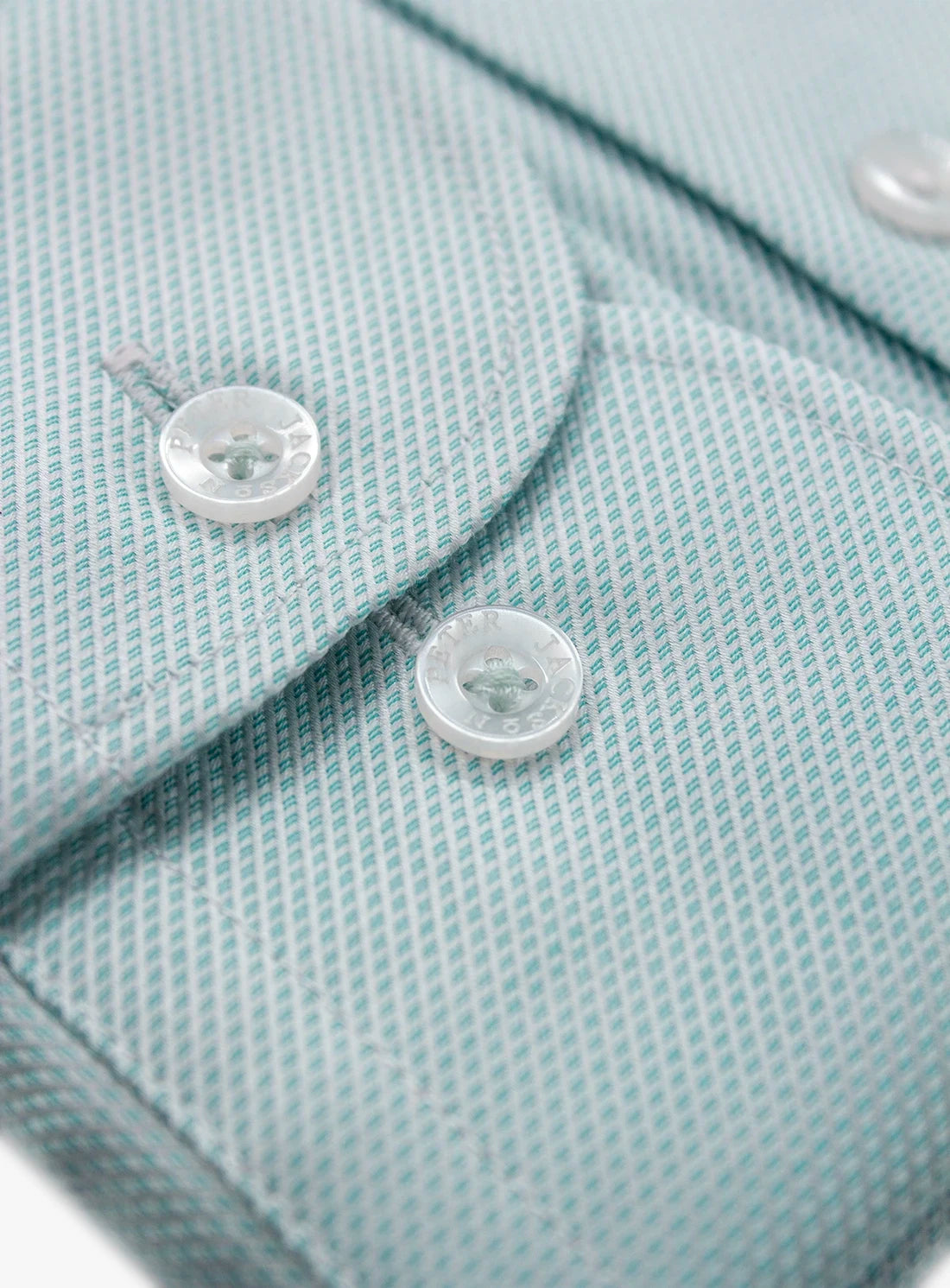 Close-up of a light blue textured fabric with buttons