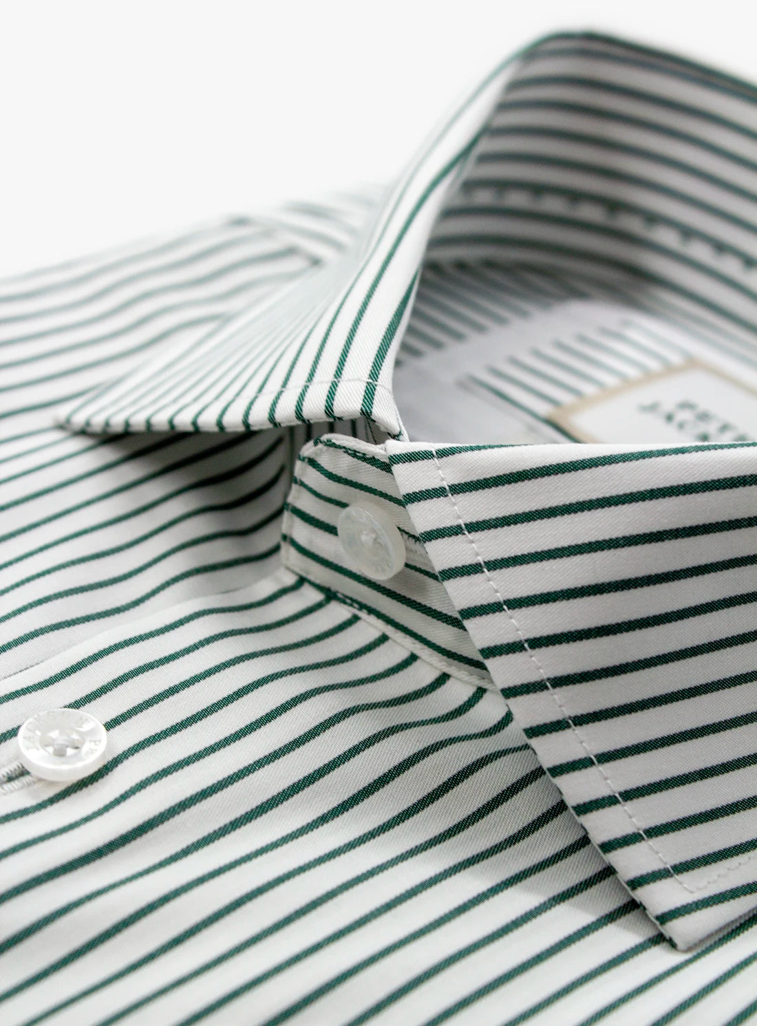 Close-up of a green and white striped shirt with a collar and buttons.