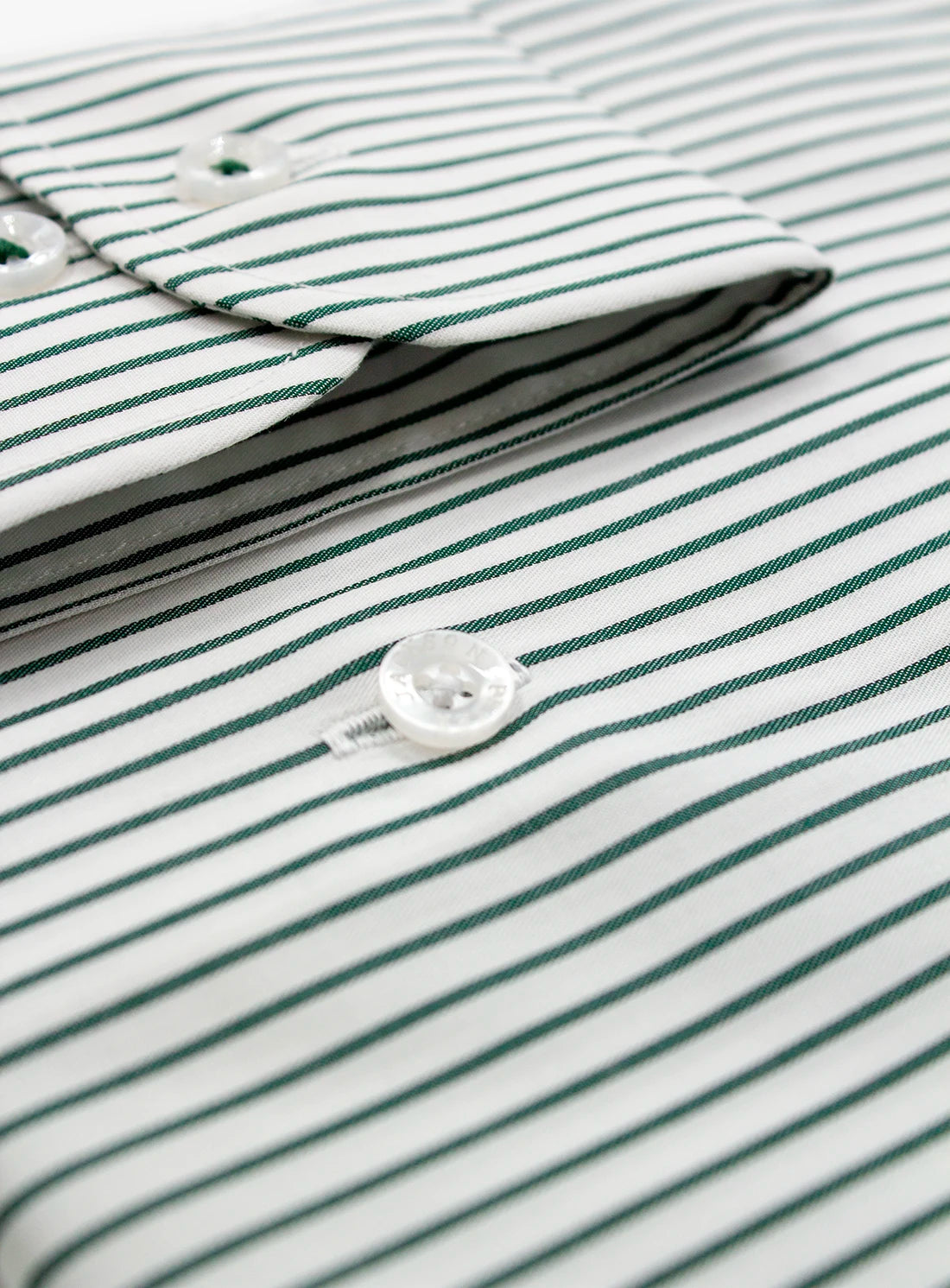 Close-up of a green and white striped shirt with a button.