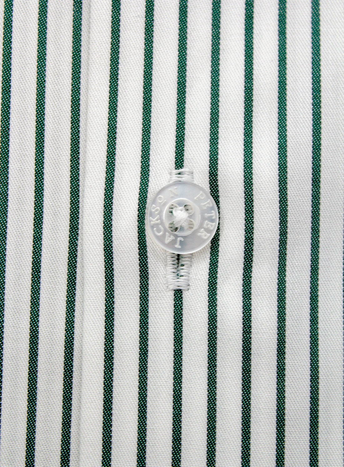 Close-up of a button on a shirt with green and white striped pattern