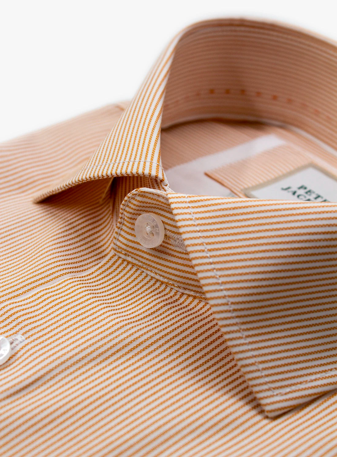 Close-up of a beige and white striped shirt with a collar and button.