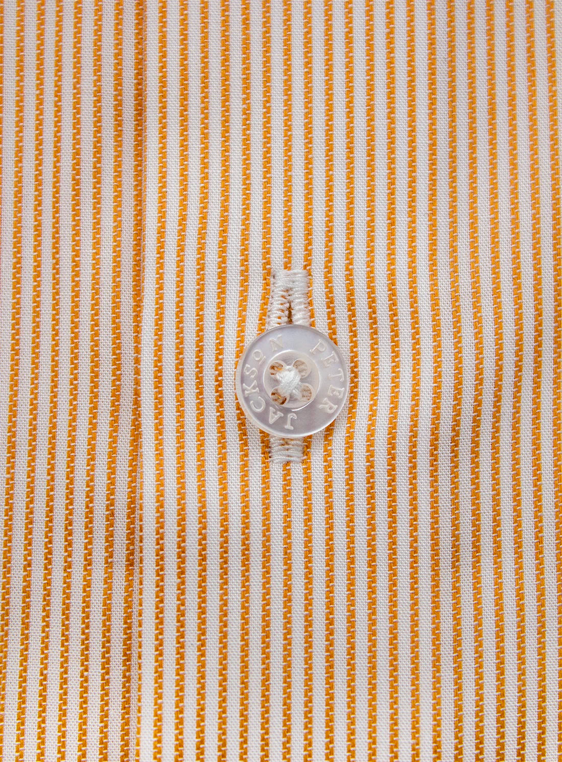 Close-up of a button on a shirt with a striped pattern