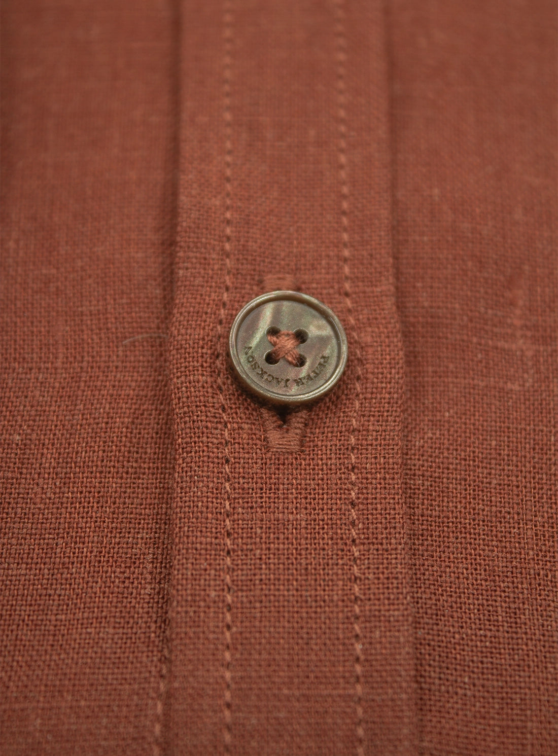 Close-up of a button on a brown fabric surface