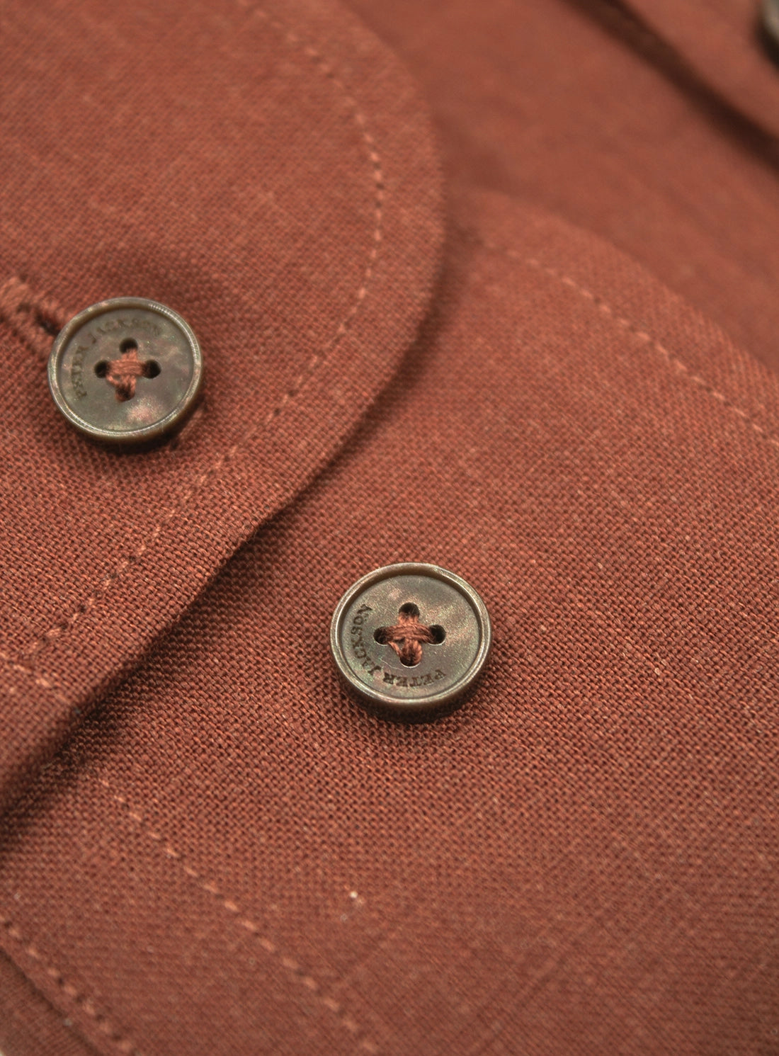 Close-up of a brown fabric with a button on a garment