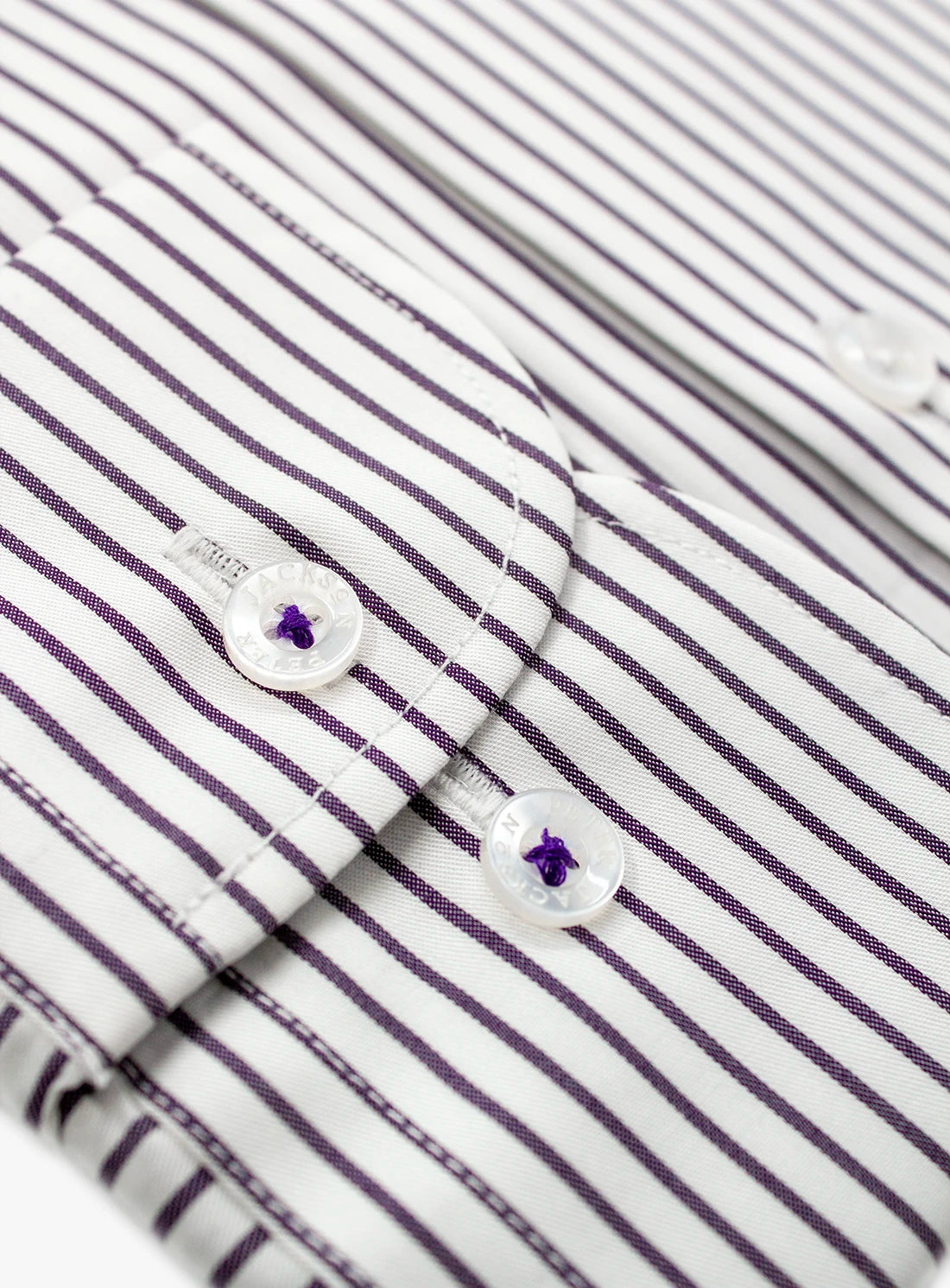 Close-up of a striped shirt with buttons and a brand label.