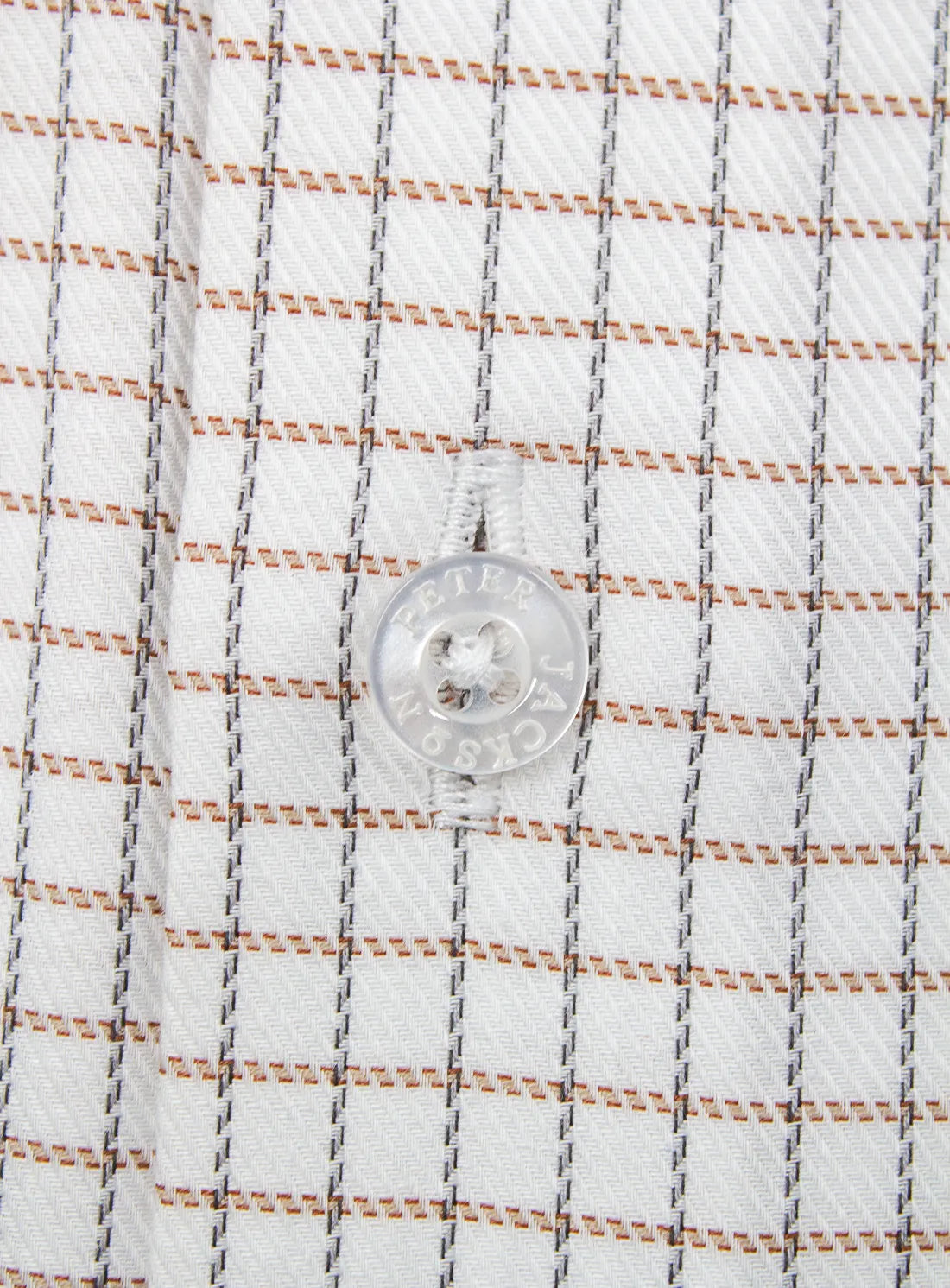 Close-up of a button on a shirt with a checkered pattern