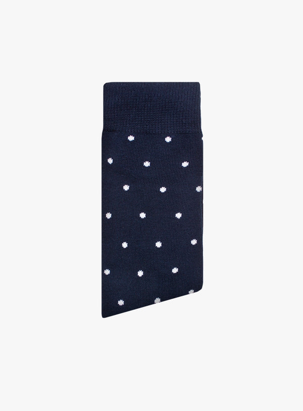 Navy sock with white polka dots on a light gray background