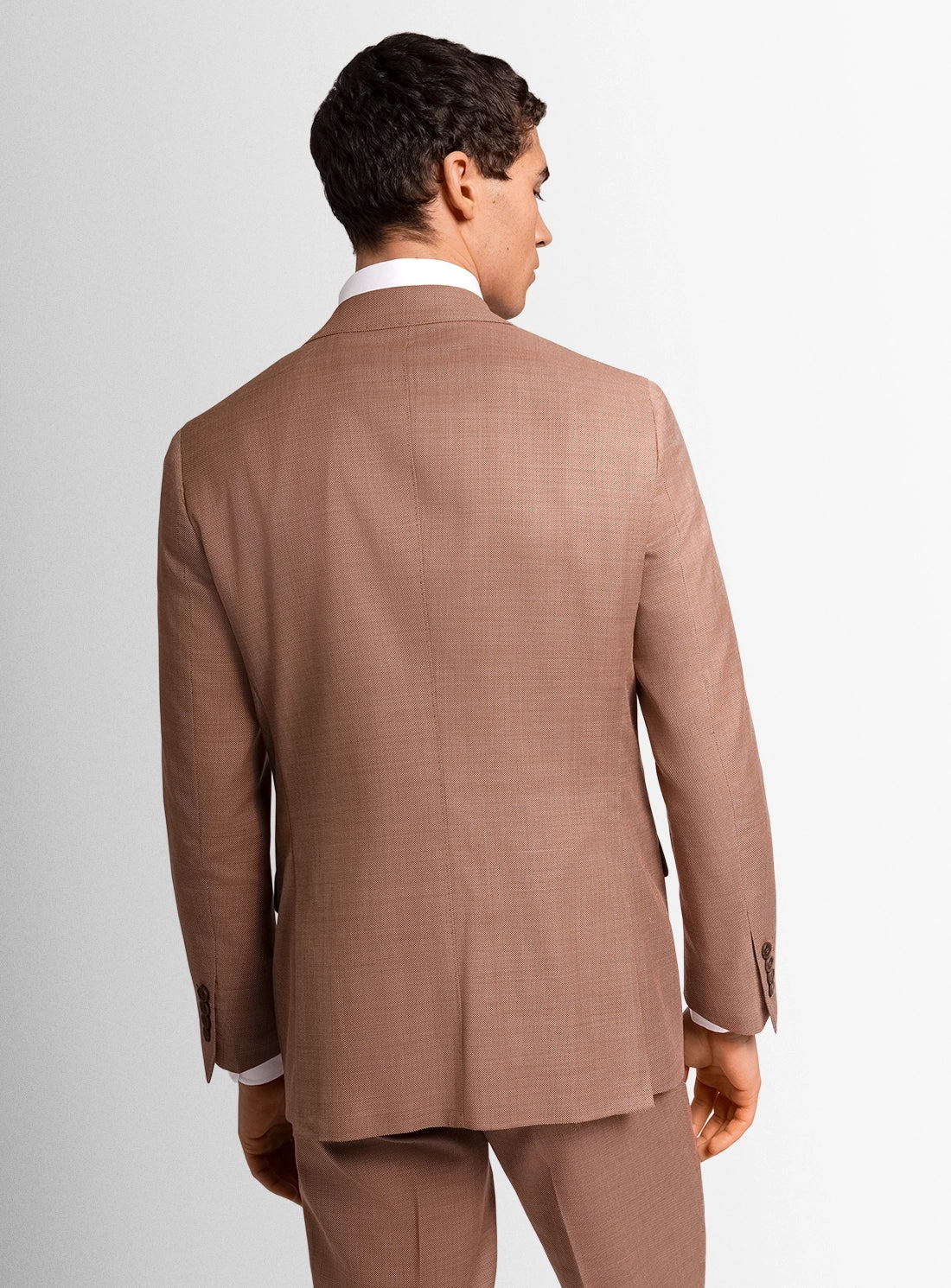 Man wearing a brown suit on a plain background