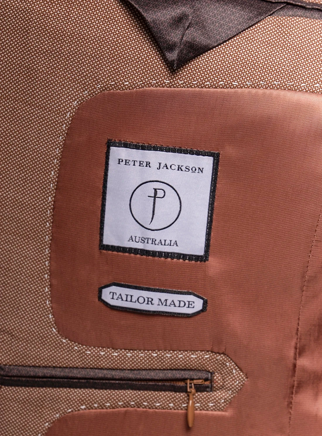 Close-up of a brown jacket with 'Peter Jackson Australia' label and 'Tailor Made' text.