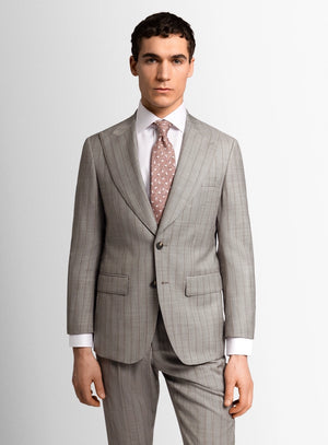 Man wearing a gray suit with a white shirt and patterned tie on a light gray background