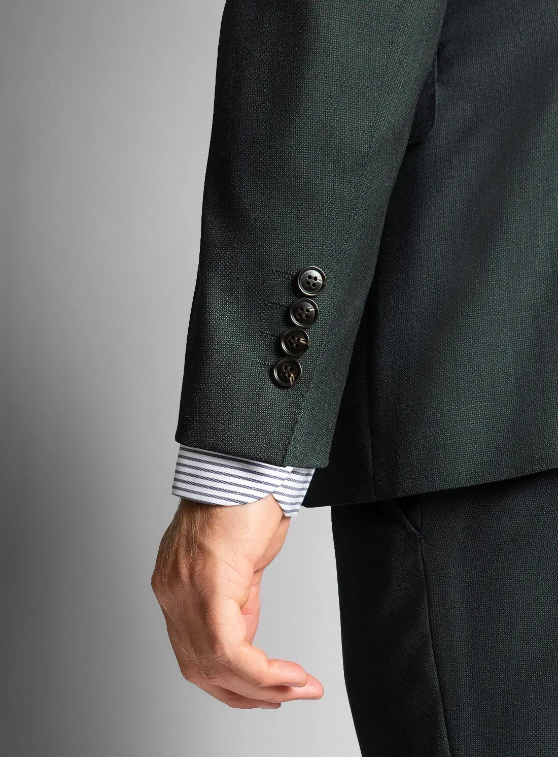 Dark green suit jacket and striped shirt on a gray background