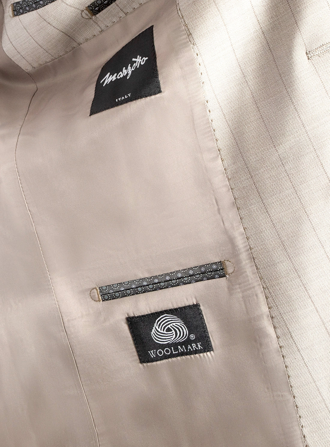 Close-up of a beige fabric with Woolmark labels on a light background