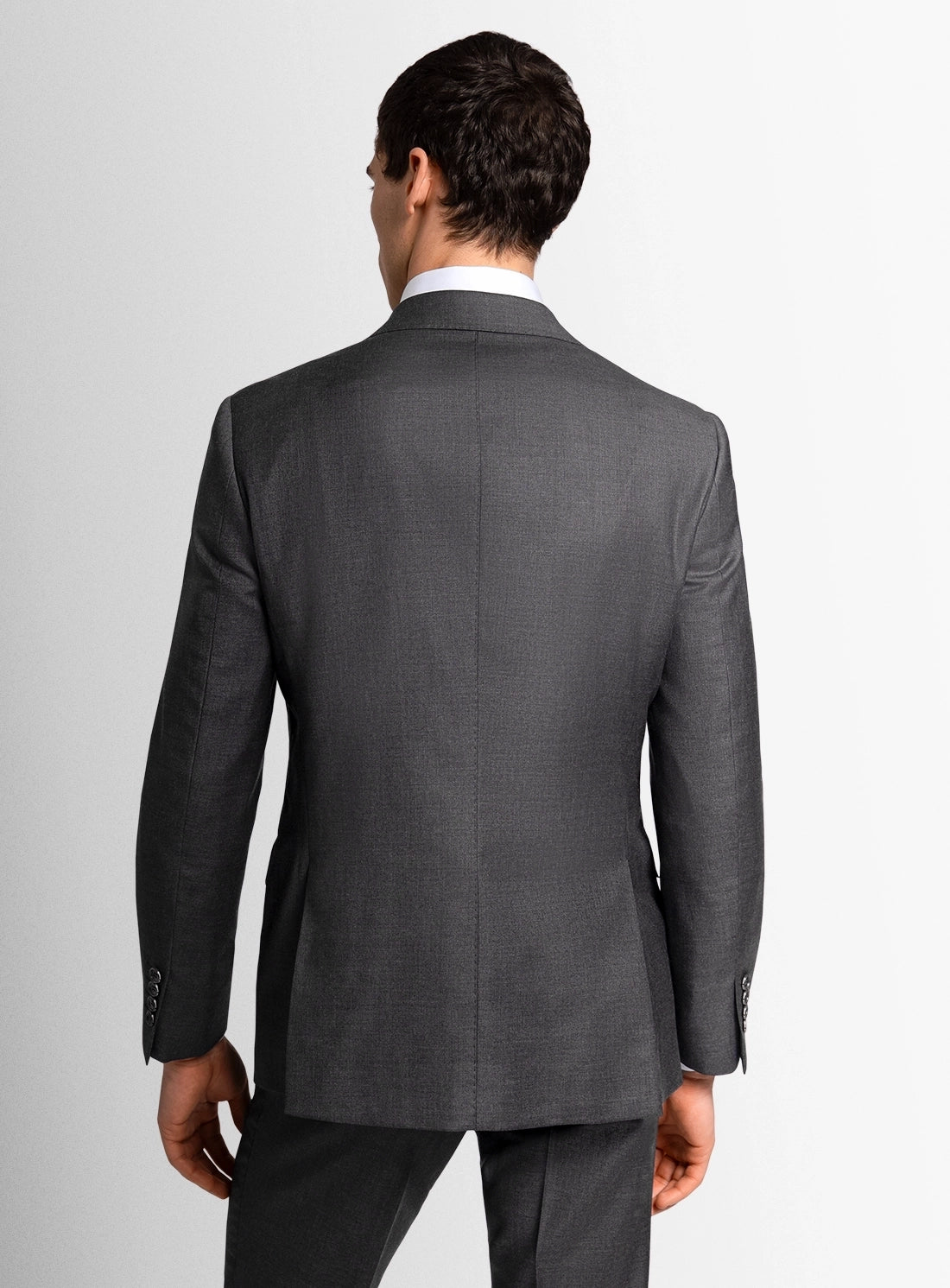 Gray suit jacket worn by a person on a light gray background