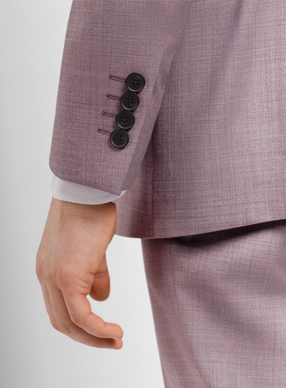 Close-up of a person wearing a purple suit with a white shirt on a light gray background