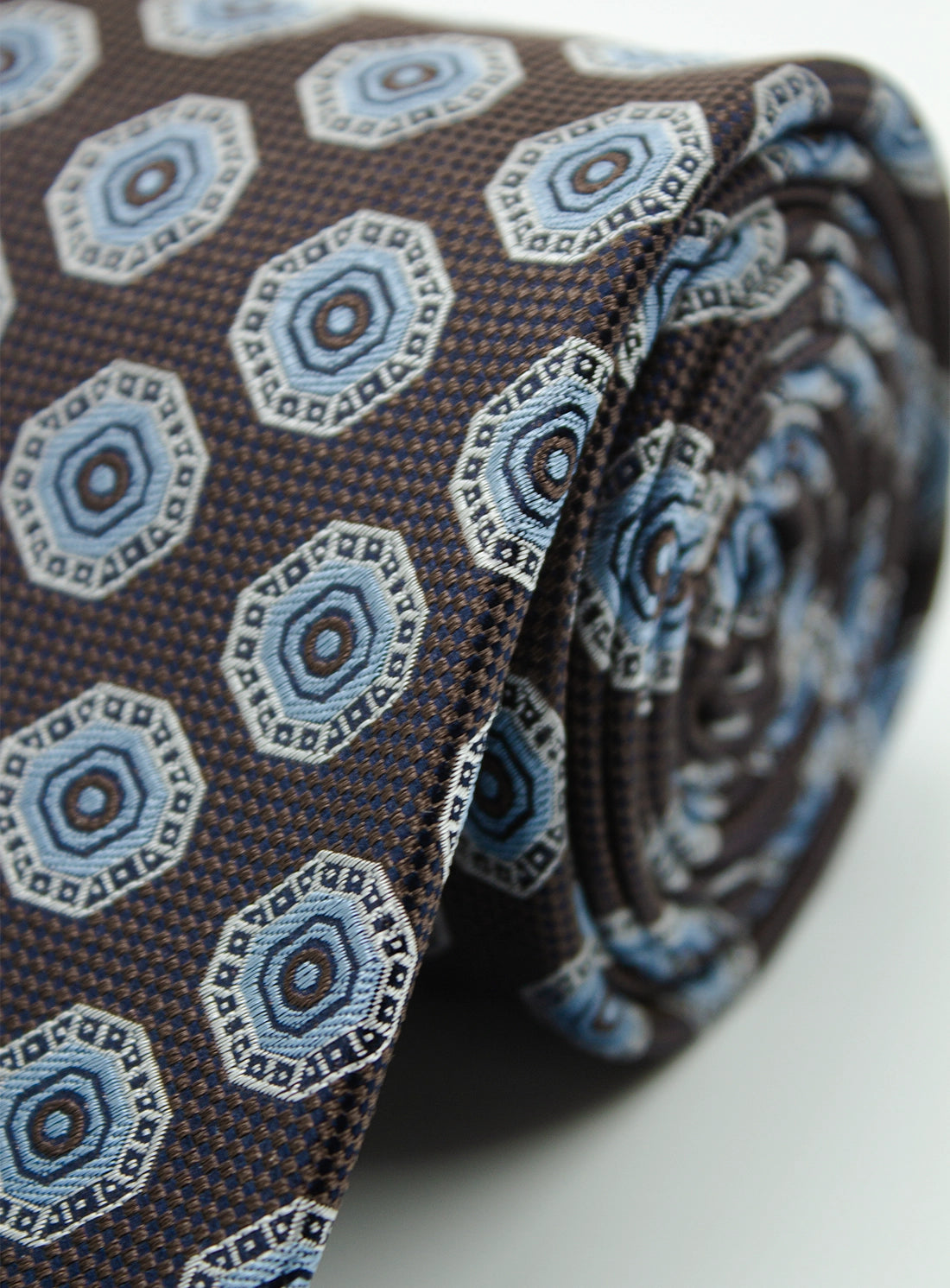 Close-up of a patterned tie with blue and brown design on a white background